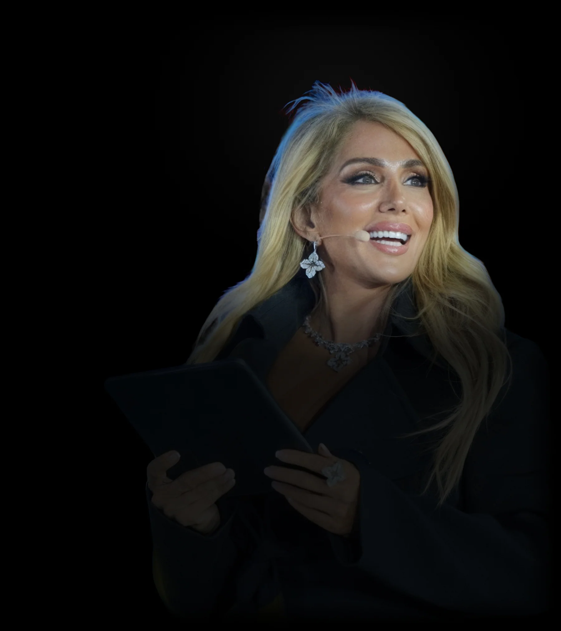 Paria Ghorashi on stage, a tablet in her hands and a headset microphone
